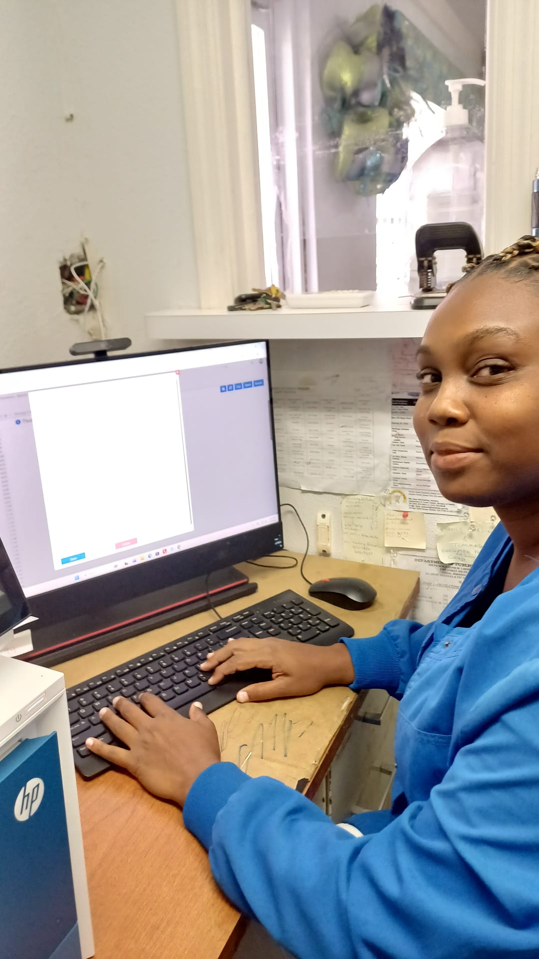 Nurse Atiya Deal working at a computer running BahamasEMR+ at Adelaide Clinic